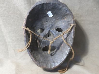 Mask of oval shape. Dark grey terracotta....