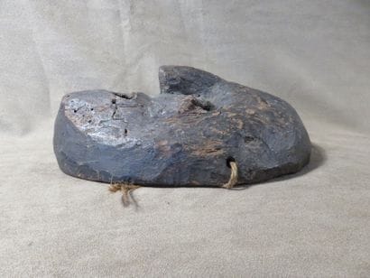 Mask of oval shape. Dark grey terracotta....