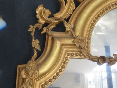Miroir à entourage en bois et stuc doré largement...