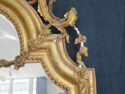 Miroir à entourage en bois et stuc doré largement...