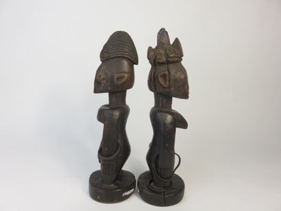 Pair of ibedji. Two statuettes, one male,...