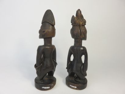 Pair of ibedji. Two statuettes, one male,...