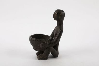 Bulul represented crouching holding a star-shaped...
