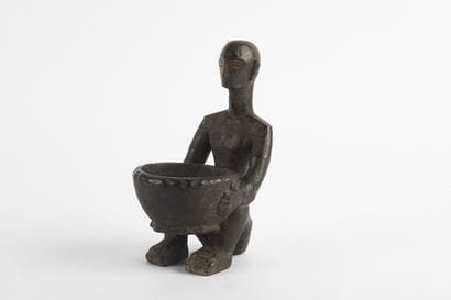 Bulul represented crouching holding a star-shaped...