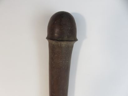Massue. Le long manche cylindrique est courbe,...