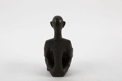 Bulul represented crouching holding a star-shaped...