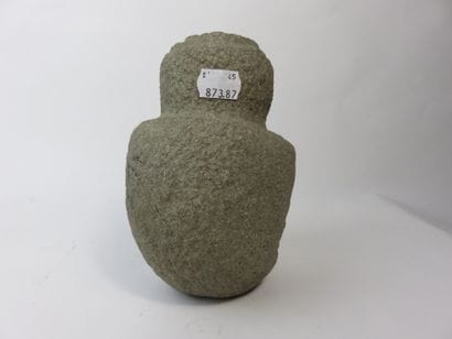Sukia. Seated figure, both hands resting...