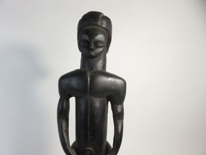 Pole top representing a male Byeri. He is...