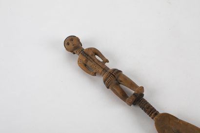 Spoon representing a woman standing with...