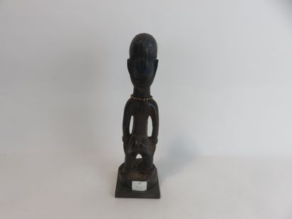 Ibedji. Female statuette, the body is realistic....