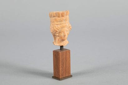 Tête féminine. Terre cuite beige. Hauteur :...