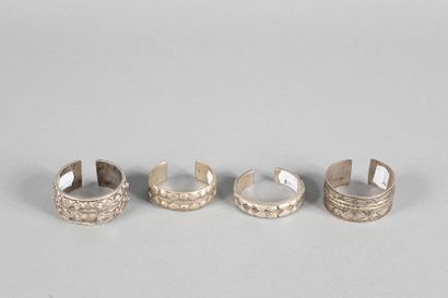 Quatre bracelets ouverts à décor géométrique,...