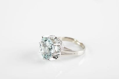White gold ring holding a round aquamarine...