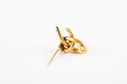 Yellow gold round wire brooch forming a knot...