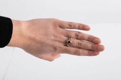 Yellow gold ring centered on an oval sapphire...