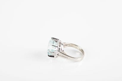 White gold ring holding a round aquamarine...