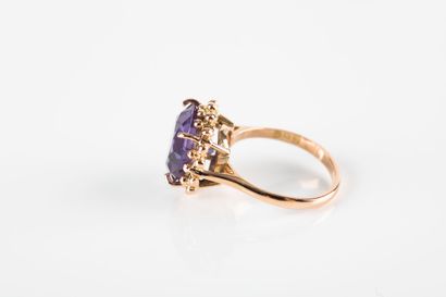 Gold ring holding a synthetic purple sapphire...