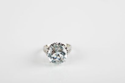 White gold ring holding a round aquamarine...