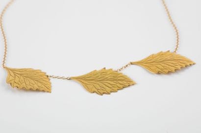 Gold necklace round forçat link, holding...