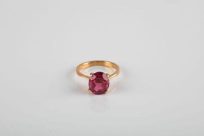 Yellow gold ring holding an oval-cut pink...