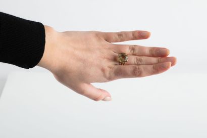 Yellow gold ring holding a round-cut citrine...