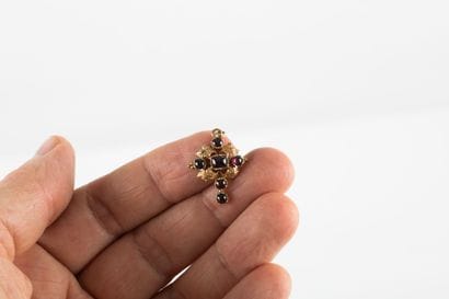Gold pendant stylizing a cross set with six...