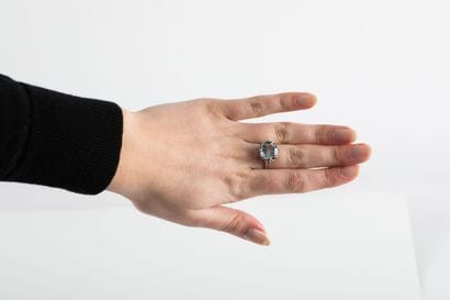 White gold ring holding a round aquamarine...