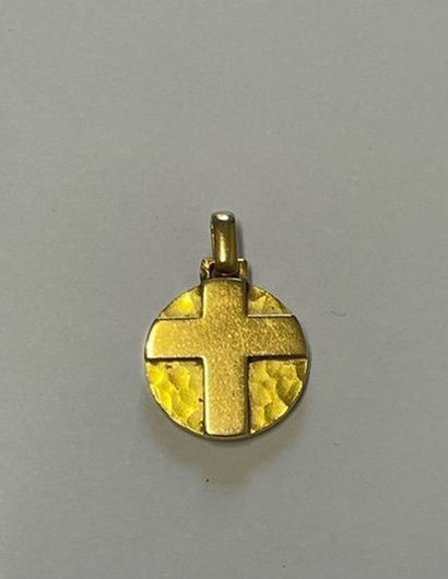 Round medal decorated with a cross in relief...