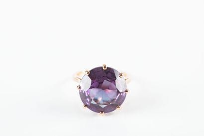 Yellow gold ring holding a synthetic sapphire...