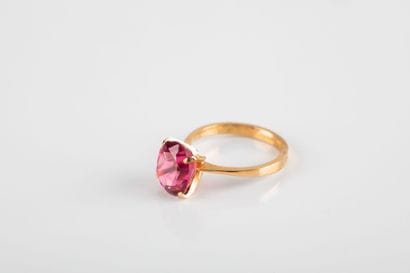 Yellow gold ring holding an oval-cut pink...