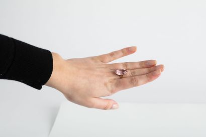 Yellow gold ring holding a shuttle-cut pink...
