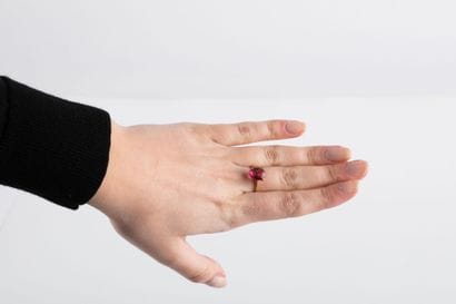 Yellow gold ring holding an oval-cut pink...