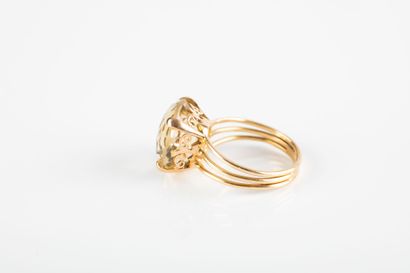 Yellow gold ring holding a round-cut citrine...