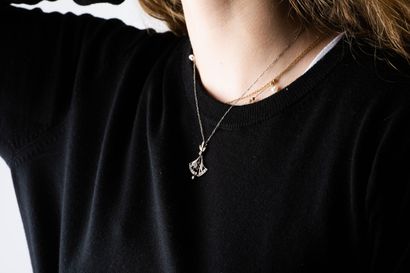 Figaro chain in platinum holding a yellow...