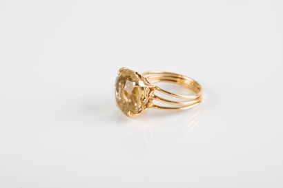 Yellow gold ring holding a round-cut citrine...