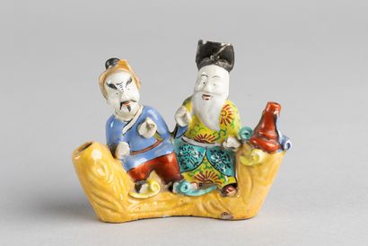 Group of two figures, one with a large white...