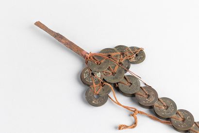 Sword-shaped coin. A red rope attached to...