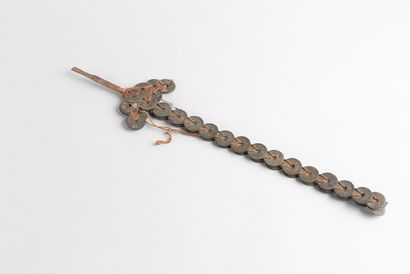 Sword-shaped coin. A red rope attached to...