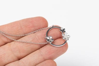 Round forcat link chain in white gold, holding...