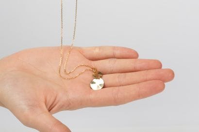 Yellow gold forcat chain with a pendant holding...