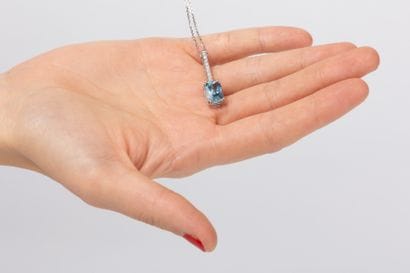 White gold chain holding a baguette pendant...