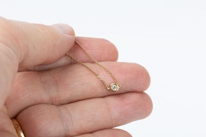 Yellow gold forcat link necklace holding...