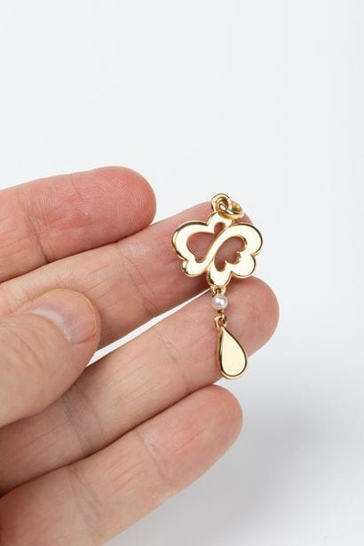 Yellow gold pendant holding a cultured pearl...