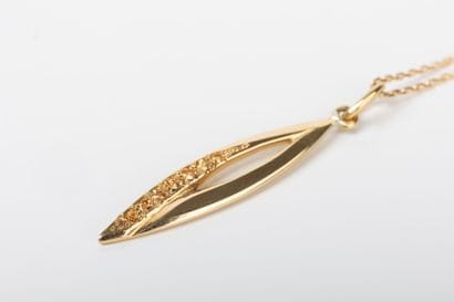 Yellow gold forcat chain holding a navette...