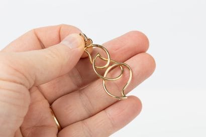 Yellow gold pendant represented by three...