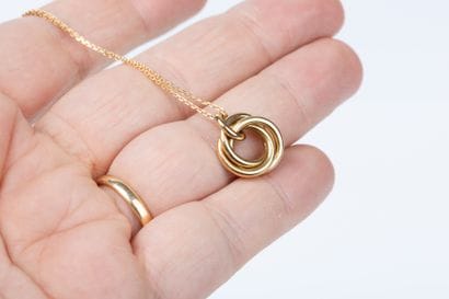 Yellow gold forcat chain holding a pendant...