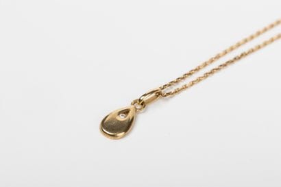 Yellow gold forcat chain holding a drop pendant...
