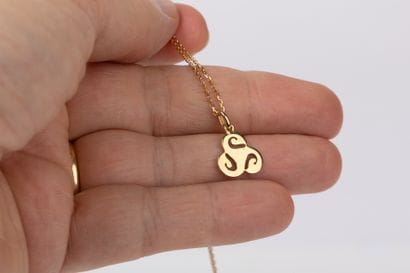 Yellow gold forcat chain with triskel pendant...
