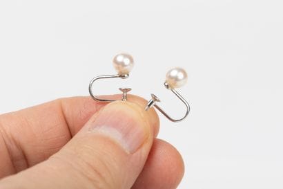 Pair of earrings in white gold, holding a...