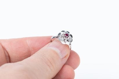 White gold ring depicting a flower with striated...